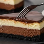 fork cutting into a slice of triple chocolate cheesecake, showing creamy layered textures and glossy ganache on a black plate.