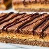 Homemade chocolate peanut butter protein bars arranged on a white plate, photographed from above on a marble surface with natural lighting