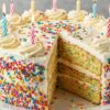 A layered birthday cake with whipped cream and candles from Simple & Easy-to-Make Birthday Cakes collection