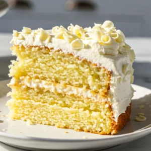 A slice of Moist Vanilla Birthday Cake on a small dessert plate