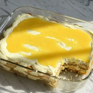 lemon tiramisu in a 9x9-inch serving dish, featuring layers of lemon-soaked ladyfingers and creamy mascarpone, topped with a vibrant lemon curd drizzle