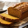 A sliced vegan pumpkin bread on a rustic wooden table