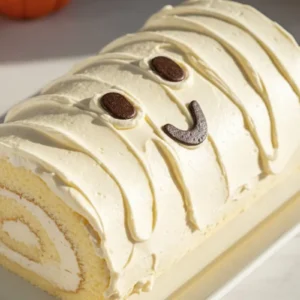 A Halloween Ghost Swiss Roll in a white rectangular dessert platter