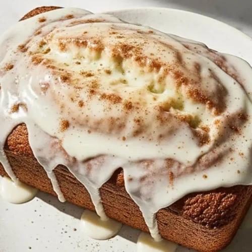 A Vegan Chai Spiced Loaf Cake on a rustic white dessert plate