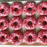 Valentine's Day Desserts - strawberry glazed donuts arranged on a white ceramic serving plate