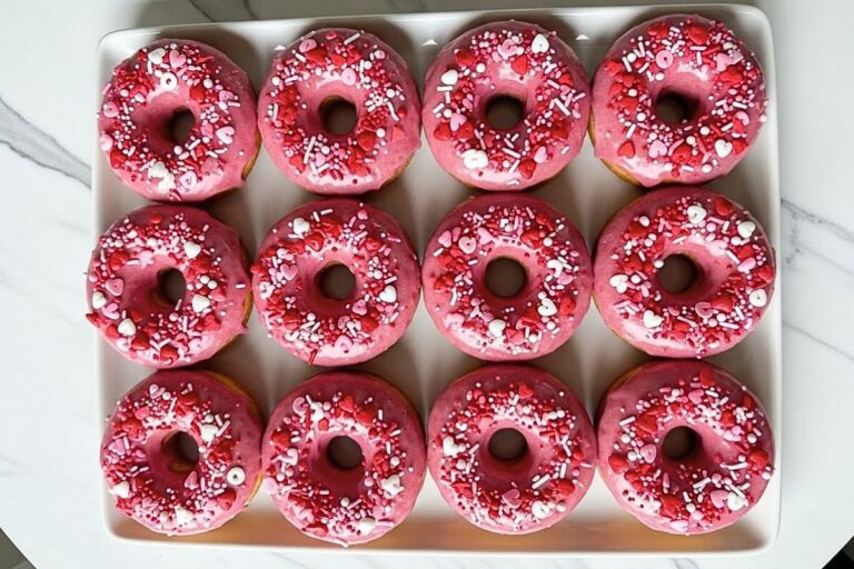 Valentine's Day Desserts - strawberry glazed donuts arranged on a white ceramic serving plate